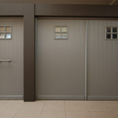 Pastorie kantelpoort met een gefreesd aluminium opdekpaneel en Présence voordeur